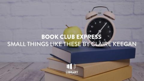 Apple and clock on a stack of books